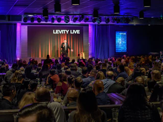 A lively comedian entertains a full audience on stage at Levity Live comedy club, creating a vibrant and enjoyable atmosphere.